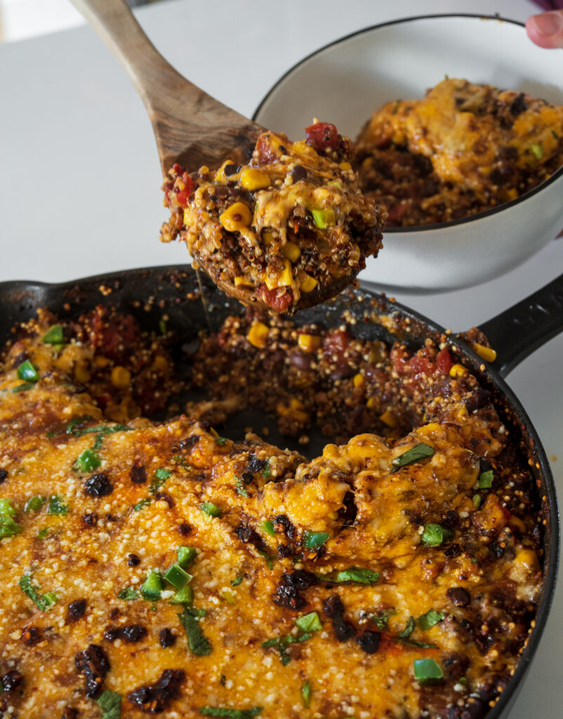 serving cheesy ground beef and quinoa from a skillet