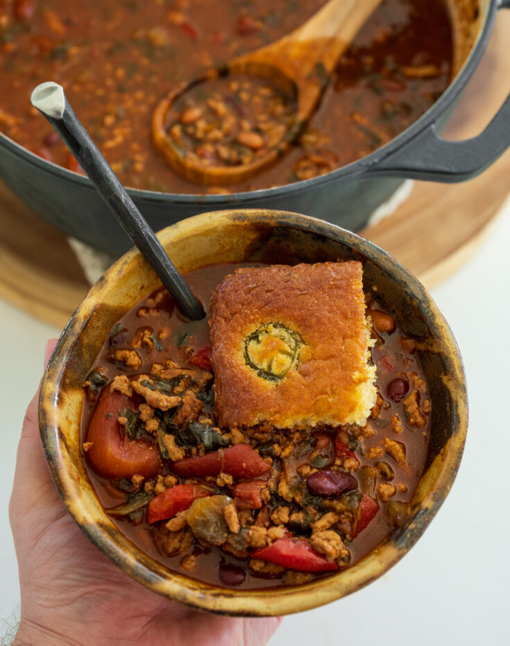 ground pork chili in a bowl with cornbread