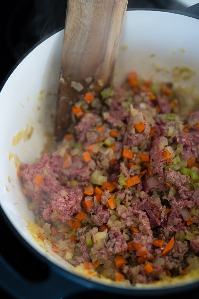 lean ground beef added to the softened onion, carrots, and celery